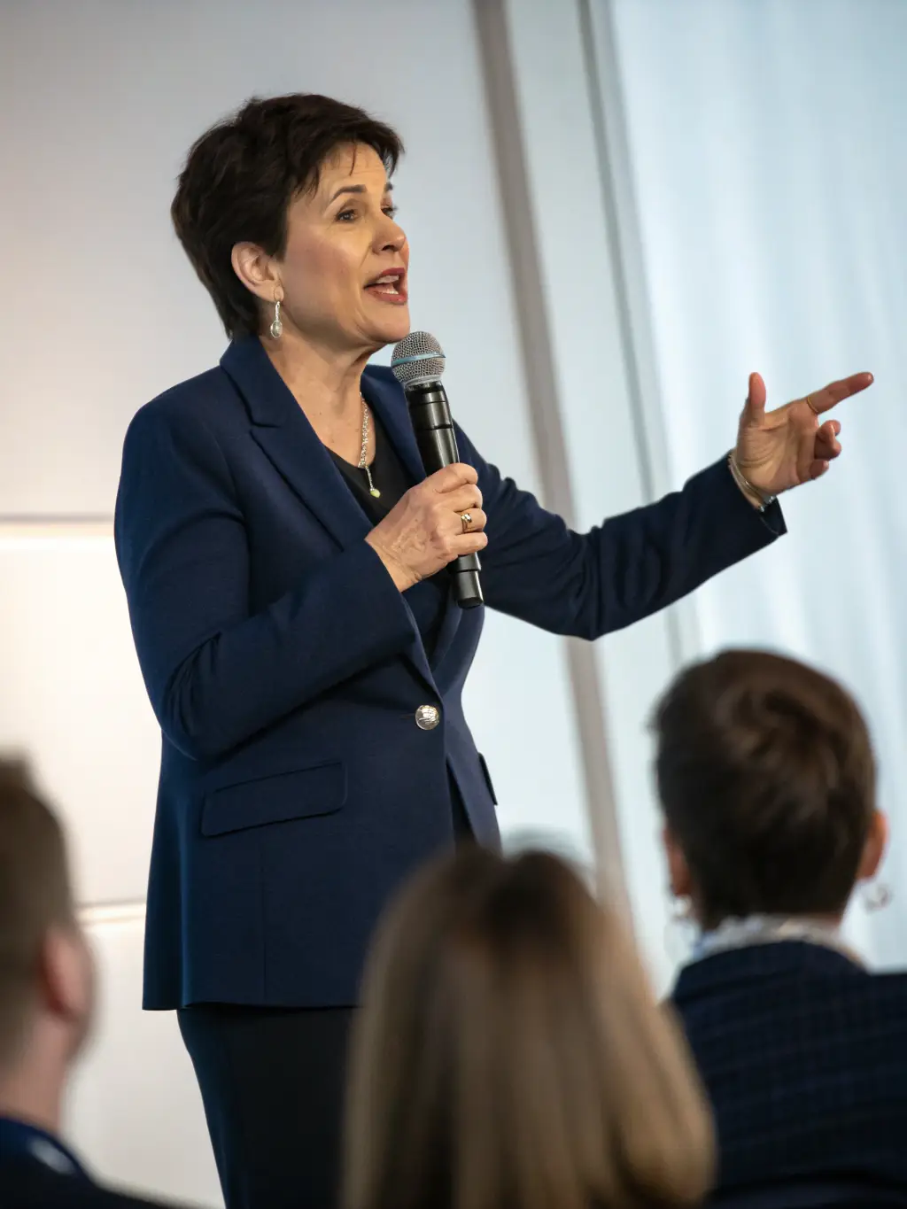 A person standing confidently on a stage, speaking to an audience, symbolizing overcoming fear of public speaking through hypnotherapy.